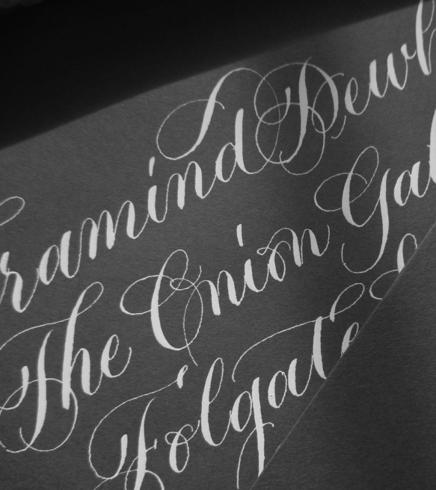 flourished-copperplate-caligraphy-white-ink-on-grey-envelopes