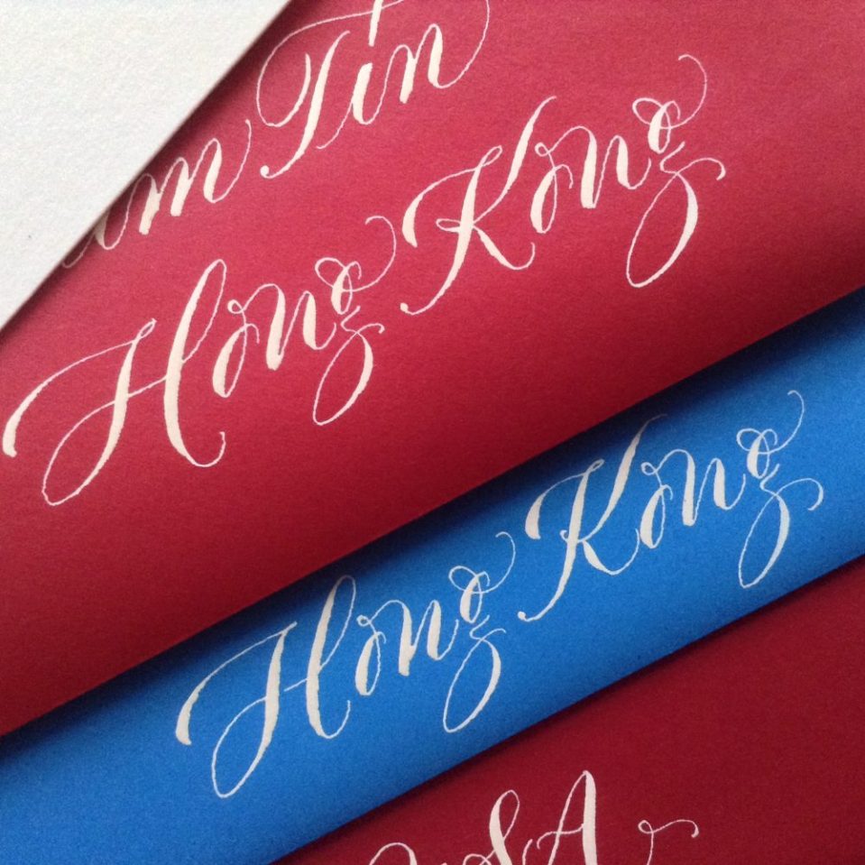 white copperplate calligraphy on red and blue envelopes.
